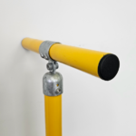 Uni - Fit black round plastic cap fitted on a yellow safety rail with galvanised fittings