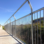 Galvanised vertical bar barrier with angled anti-climb top on pedestrian path